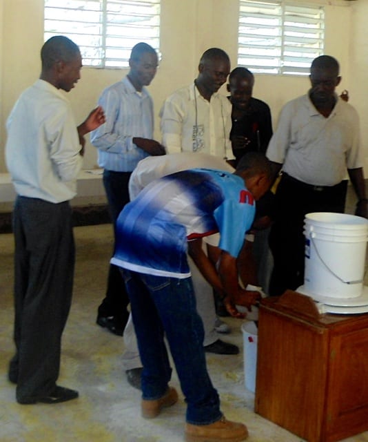 Participants gather round to check out SOIL's demonstration toilet and handwashing materials.
