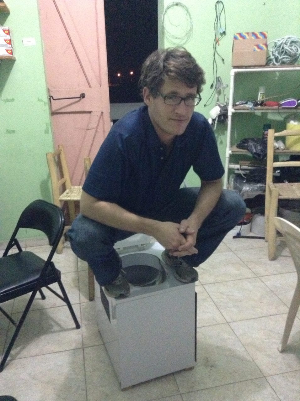 Lead author Kory Russel testing to make sure the toilet design is sturdy at SOIL's office in Cap Haitien.
